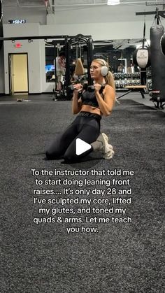 a woman squatting on the ground in a gym