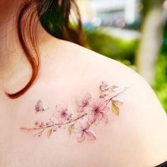 a woman's shoulder with pink flowers on it