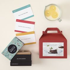 a table topped with boxes and cards next to a cup