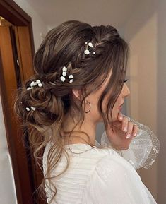 a woman with long hair and flowers in her hair is looking at herself in the mirror