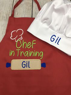 two aprons with chef in training written on the front and one has a chef's hat