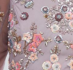 a close up view of the back of a woman's dress with flowers on it