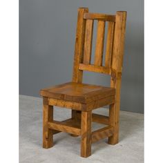 a wooden chair sitting on top of a white floor next to a gray wall in a room