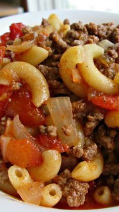 a white bowl filled with pasta and meat