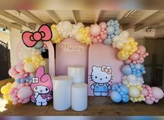 a hello kitty themed birthday party with balloons and heliums on the walls, including an arch