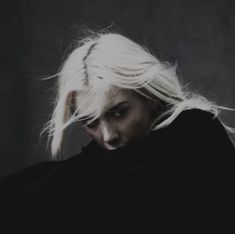 a woman with white hair is looking down