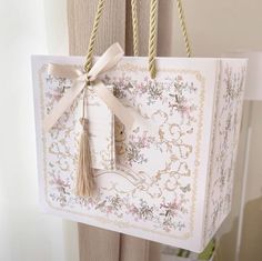 a gift bag hanging from the side of a door with a tassel on it