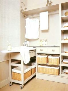 a white bathroom with lots of shelves and baskets