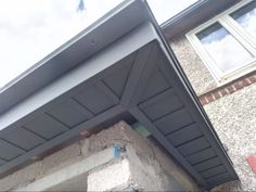 the corner of a house with a window and gutter