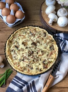 a pie sitting on top of a wooden table next to eggs