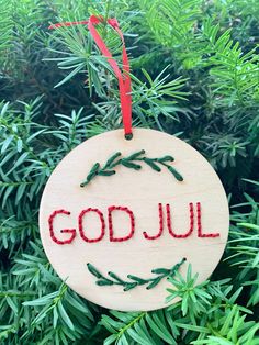 a wooden ornament with the words god jul on it hanging from a tree