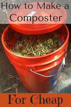 two red buckets filled with grass sitting next to each other on top of a dirt ground