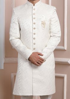 Ready-Made Sherwani With Trouser. Jacquard Brocade Fabric Top. Art Dupion Aligarhi Ready Made Trouser. Crafted in Chinese Collar Neck, and Full Sleeve. Satin Lining with Plain Work. High-Quality Matching Buttons. Please Note: The footwear shown in the picture is for presentation and photography purpose only. Color: There might be slight color variation due to lightings and flashes while photo shooting. The color may also vary because of different screen resolutions. Wash Care: Dry Clean Only. King Attire Outfit, Shervani Design For Men Simple, Wedding Suits With Resham Embroidery For Diwali, White Raw Silk Kurta For Formal Occasions, Formal White Raw Silk Kurta, Formal White Raw Silk Traditional Wear, Ceremonial Jamawar Sets With Intricate Embroidery, Elegant Sherwani With Intricate Embroidery In Art Silk, Elegant Art Silk Bandhgala With Chikankari Embroidery