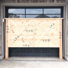 a large wooden gate with numbers on it in front of a brick wall and garage door