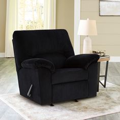 a black recliner chair sitting on top of a rug