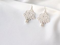 Minimalistic lace earrings with pearl will be an exclusive addition to your wedding look! These dangle tatting ivory earrings are very lightweight and comfortable to wear. MEASUREMENTS: earring height (minus ear wire): 4 cm earring total height (including ear wire): 5,5 cm earring width (widest point): 3 cm These earrings are ready to be shipped. Handmade Delicate Pearl White Bridal Earrings, Handmade Silver Pearl Chandelier Earrings, Delicate Handmade Pearl White Bridal Earrings, Handmade White Pearl Chandelier Earrings, Elegant White Pearl Earrings With Filigree, Elegant White Filigree Pearl Earrings, Elegant Silver Lace Jewelry, Handmade Silver Pearl Bridal Earrings, Delicate Handmade White Chandelier Earrings