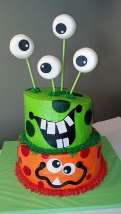 a green cake with monster faces on it