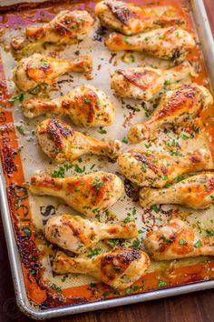 baked chicken wings on a baking sheet ready to be cooked in the oven with parsley