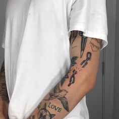 a man with tattoos on his arm holding a knife