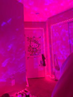 a hello kitty themed bedroom with pink lighting and decorations on the walls, along with an open closet door