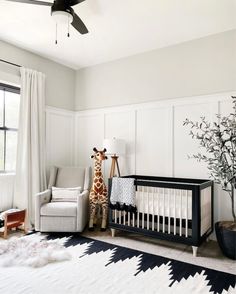 a baby's room with a giraffe in the crib and a chair