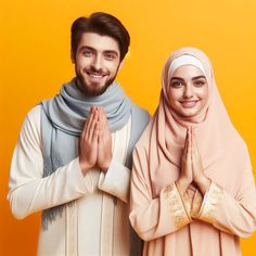 two people standing next to each other with their hands in the air and smiling at the camera