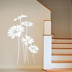 a white flower wall decal on the side of a stair case next to a banister