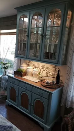 a blue china cabinet with glass doors in a living room