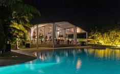 an outdoor swimming pool at night with lights on