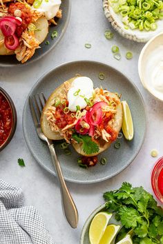 three plates with tacos, salsa and limes on them next to some drinks