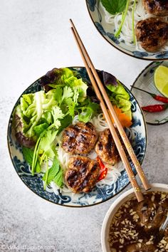 two plates filled with meat and vegetables next to chopsticks