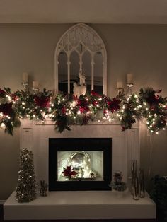 a fireplace decorated with christmas garland and lights