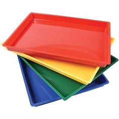 four different colored trays stacked on top of each other