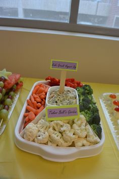 a table topped with lots of different types of food next to a window filled with fruit and veggies