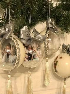 three ornaments hanging from a christmas tree with pictures on them and ribbons around the ornaments