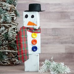 a wooden snowman with a hat and scarf