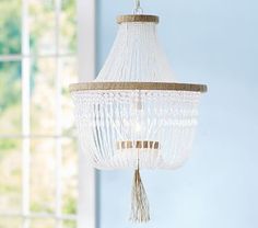 a white chandelier hanging from the ceiling with text reading, pottery barn kids