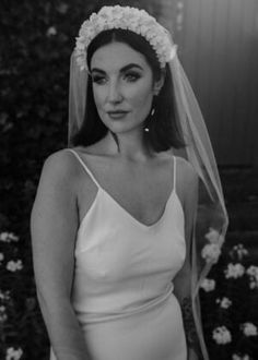 black and white photo of woman in wedding dress with veil over head wearing flower crown