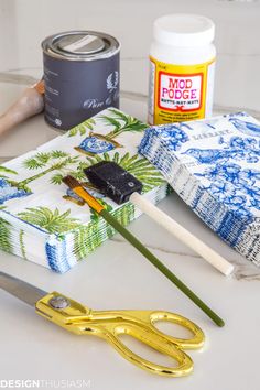 some craft supplies are laying out on a white counter top with paint, scissors and glue