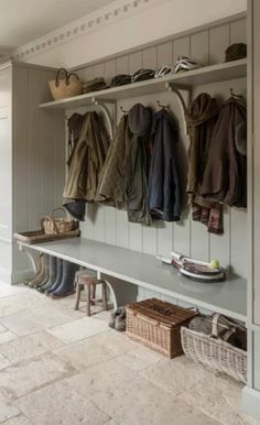 a coat rack filled with coats and shoes next to a wall mounted shoe rack in a hallway