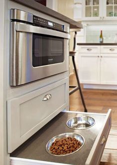 a stainless steel dog bowl and microwave in a kitchen