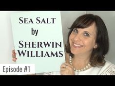 a woman holding up a sign that says sea salt by sherwin williams