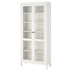 a white bookcase with glass doors on the front and bottom shelves, against a white background