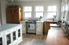 a kitchen with wooden floors and white cabinets