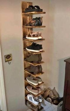 a wooden shoe rack filled with lots of shoes in a room next to a door