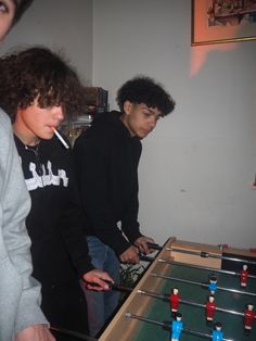 two young men playing foo pong in a living room