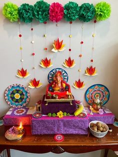 there is a small shrine on the table with decorations around it and candles in bowls