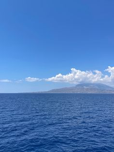 an island in the middle of the ocean under a blue sky