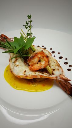 a white plate topped with food and garnished with green leafy garnish