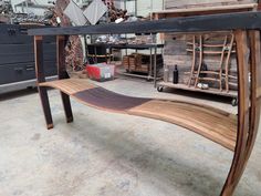 a wooden bench sitting inside of a garage next to other furniture and tools on display